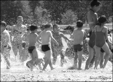 Groupe d'enfants s'amusant sous la surveillance d'adultes.